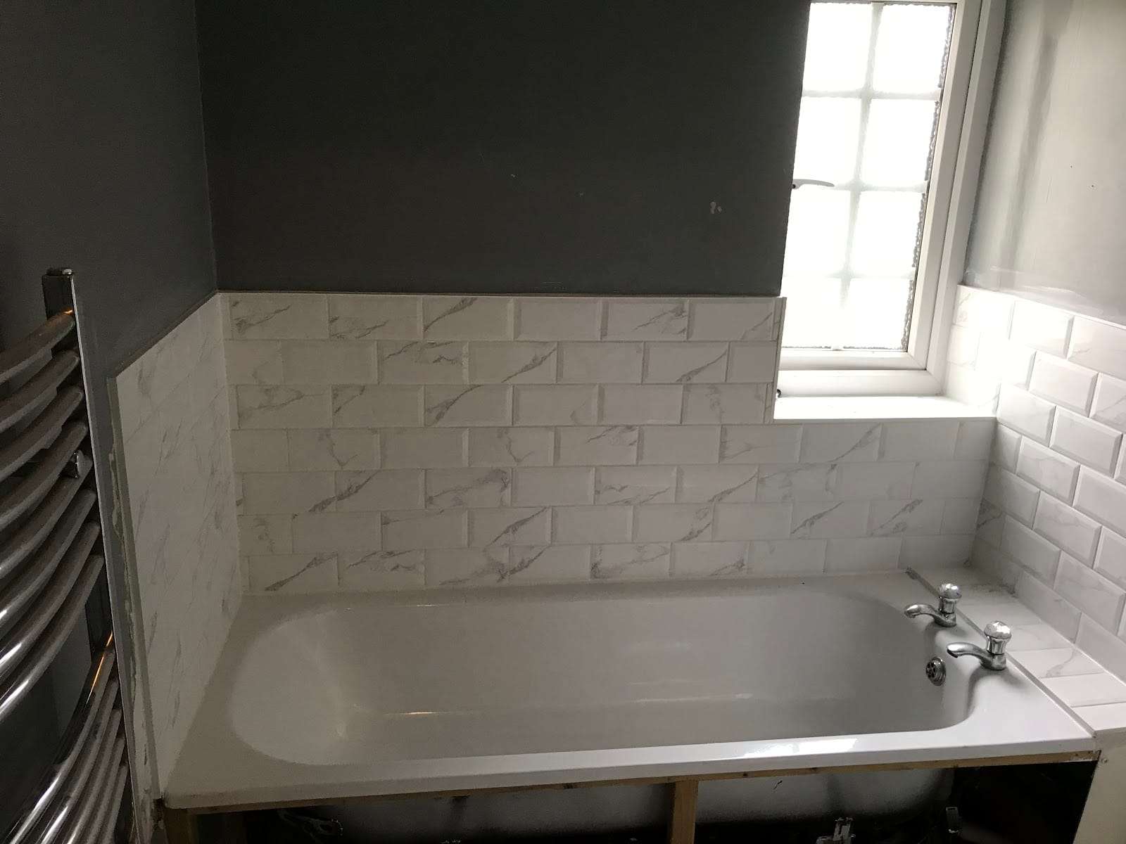Marble effect metro bath surround, by Roman Tiling Services